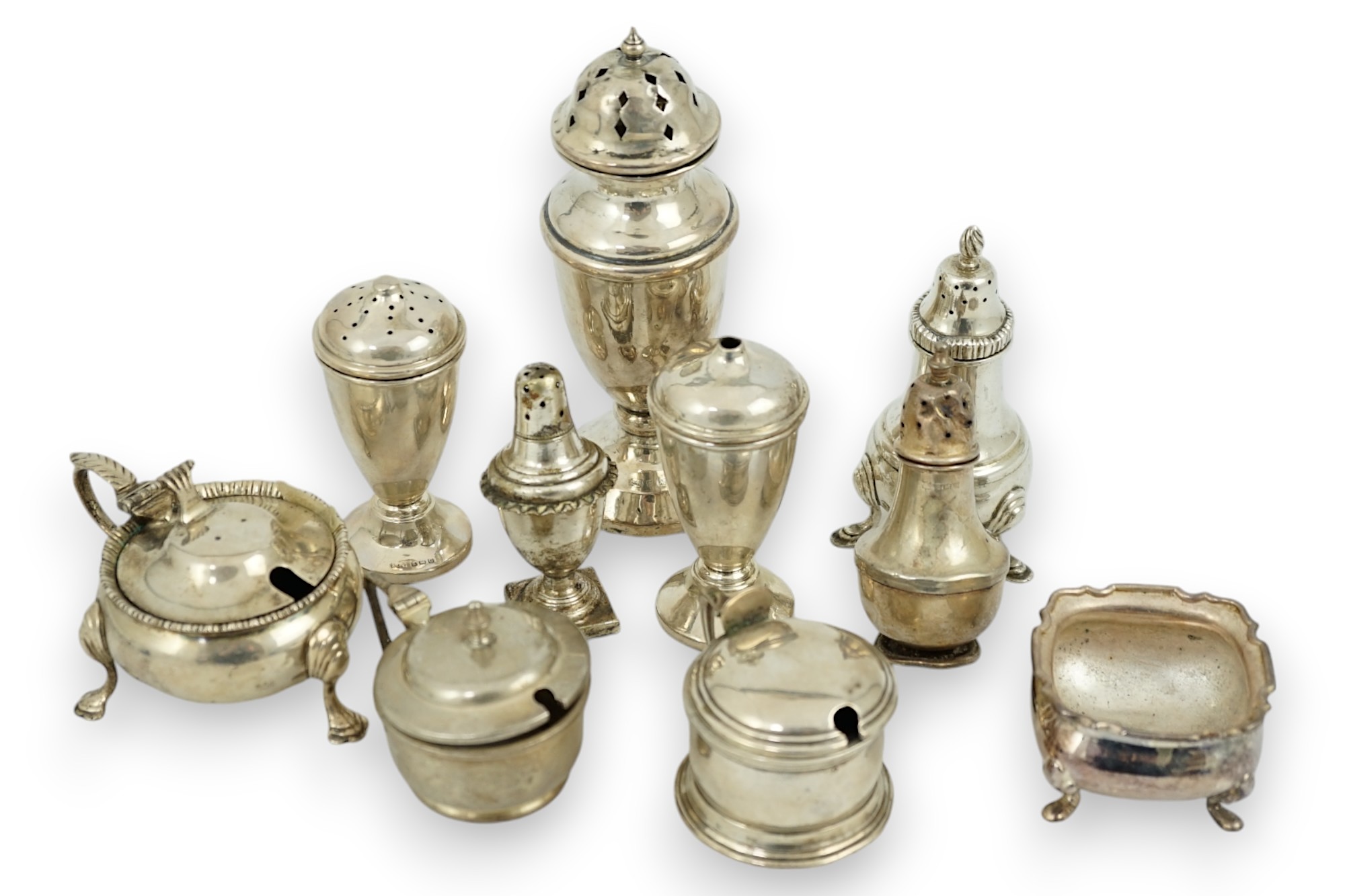 Nine assorted early 20th century and later silver condiments, various dates and makers and one plated condiment.